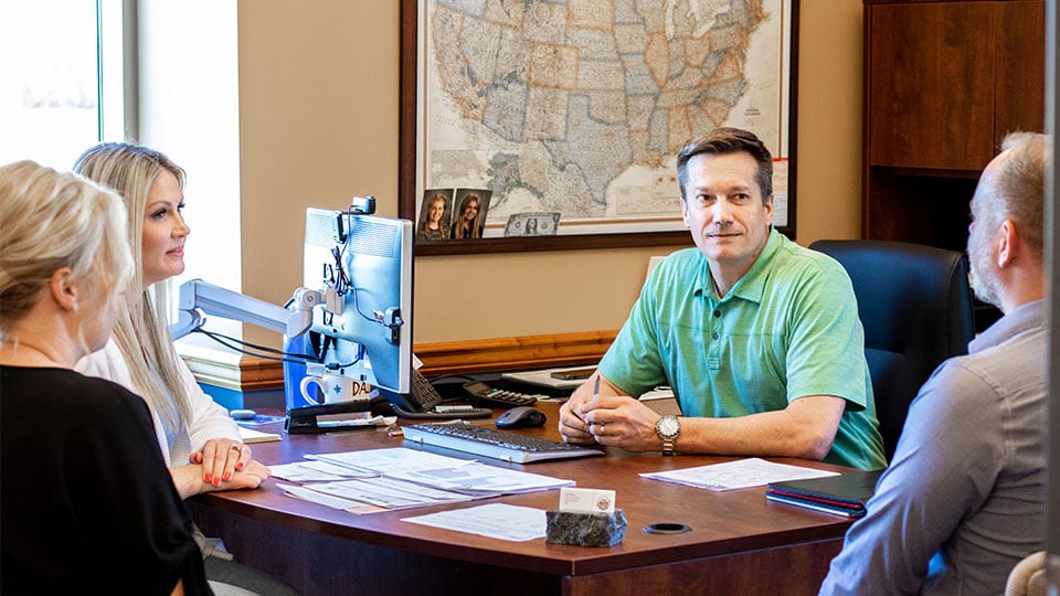 Four-Employees-in-Manager-Office-Talking